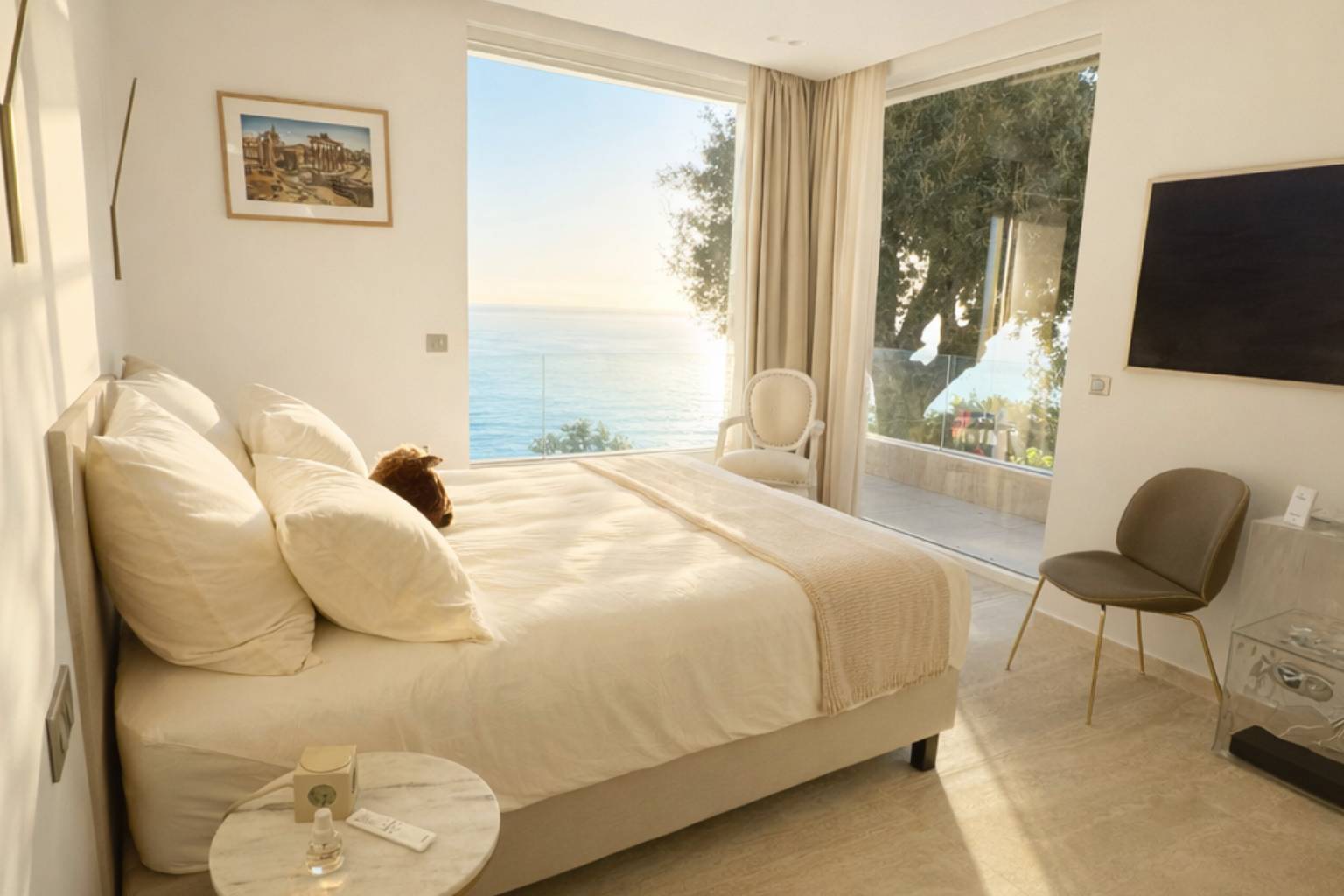 Bright Roma Suite with king-size bed and bay window opening onto direct sea views