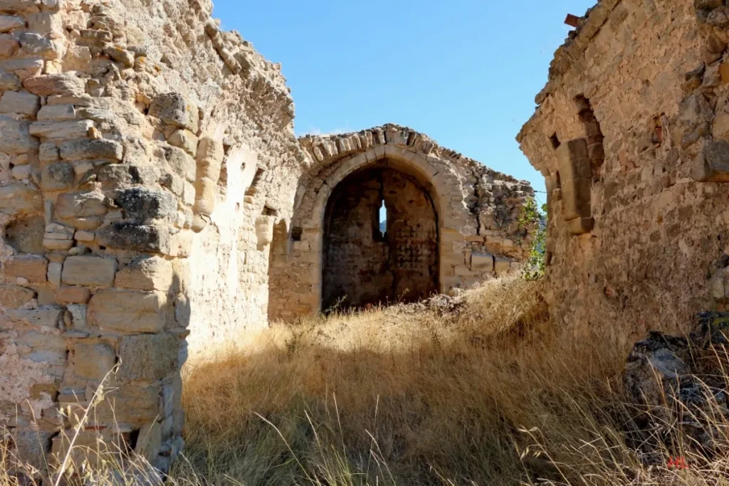 Ruines de murs en pierre et arche ancienne au milieu de la végétation