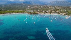 Baie de Pinarello avec plage de sable clair et bateaux au mouillage