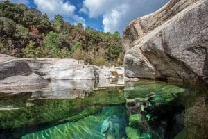 Bassins naturels de la rivière du Cavu avec eau claire, rochers et pins, lieu de baignade en pleine nature