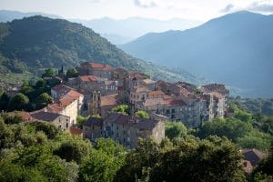 Village of Sainte-Lucie with stone houses and mountains in background